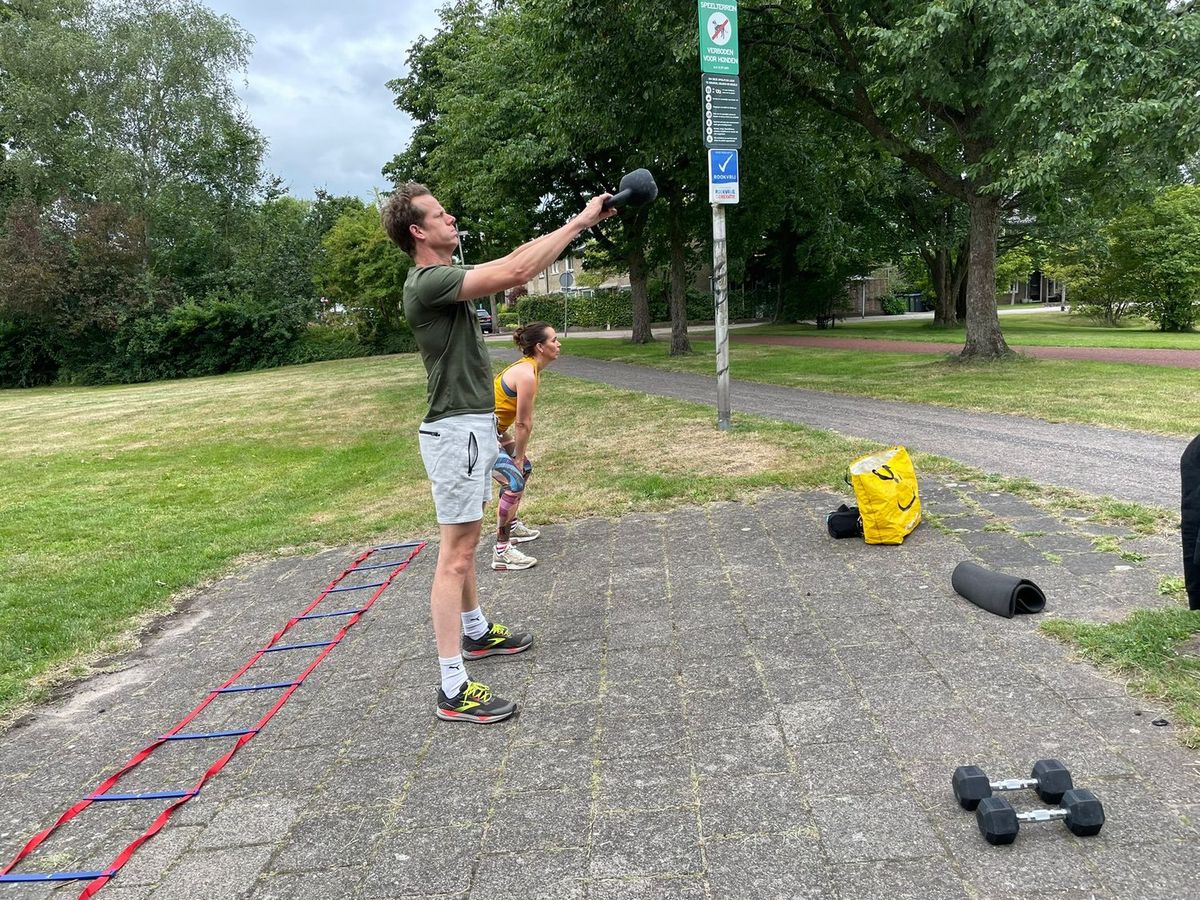 Trainster pakt materiaal uit op een pad in het park